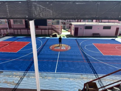 Multicancha del Colegio San Antonio de Matilla después, con piso modular azul y rojo y el logo del colegio