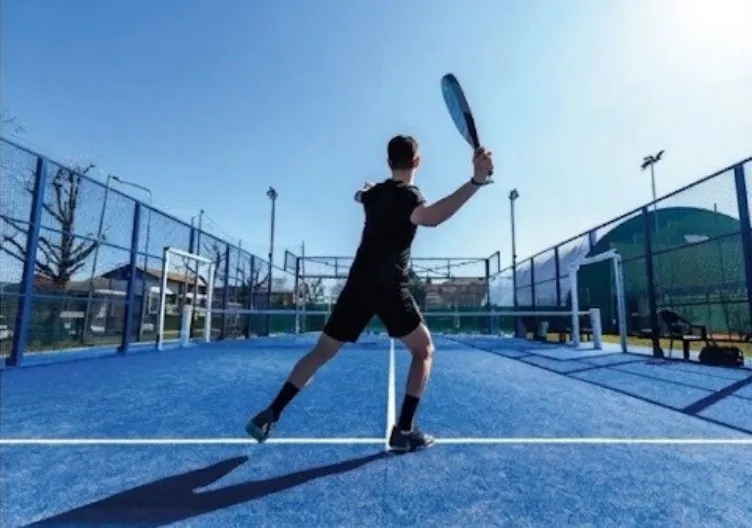 Jugador en cancha de pádel con césped artificial