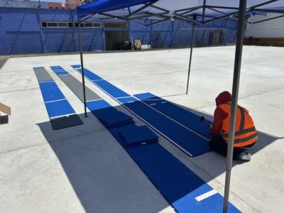 Instalador de Emisport armando las primeras filas de baldosas sobre la losa nivelada en la Universidad Arturo Prat
