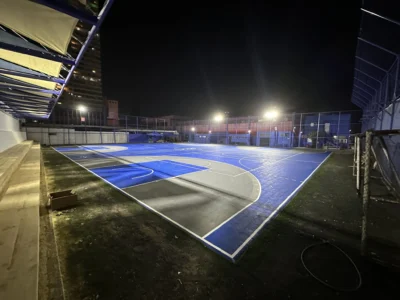 Multicancha exterior de la Universidad Arturo Prat después, con piso modular azul iluminada de noche