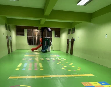 Sala del Colegio Don Bosco después, con piso verde y juegos psicomotores demarcados
