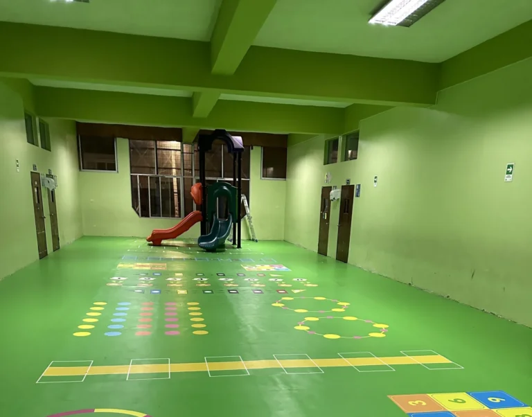 Sala del Colegio Don Bosco después, con piso verde y juegos psicomotores demarcados