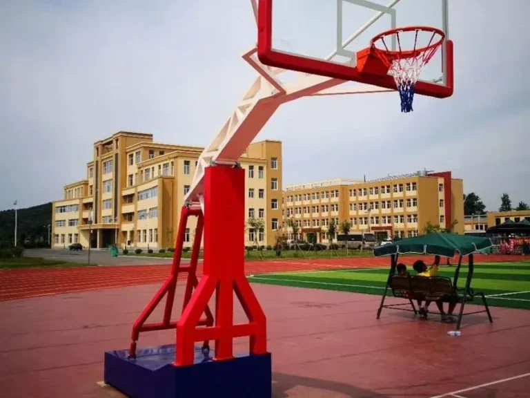 Soporte de básquetbol hidráulico de brazo largo en una cancha exterior de colegio